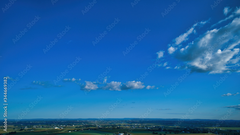 Blue sky and multiple clouds background showing a horizon