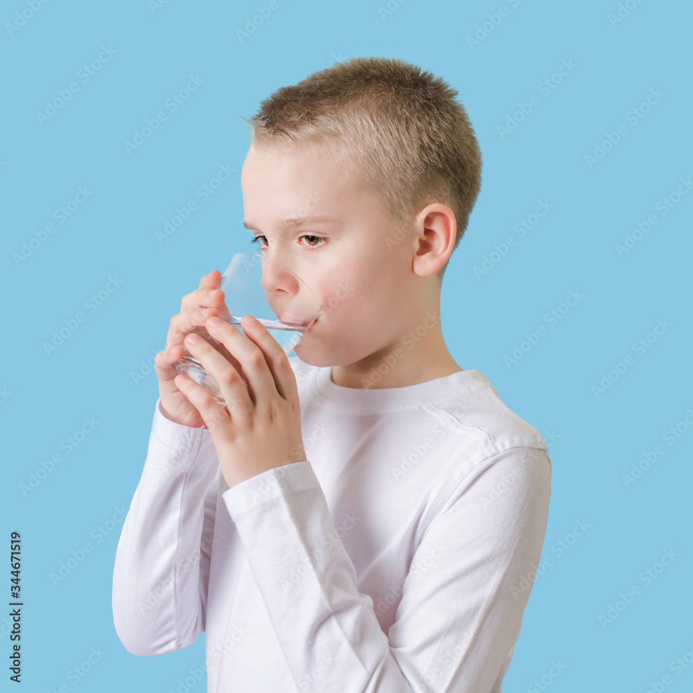 Cute child drinking clean water from glass. Blond little boy with water glass. Cute child drinking clean water from glass. Blond little boy with water glass.