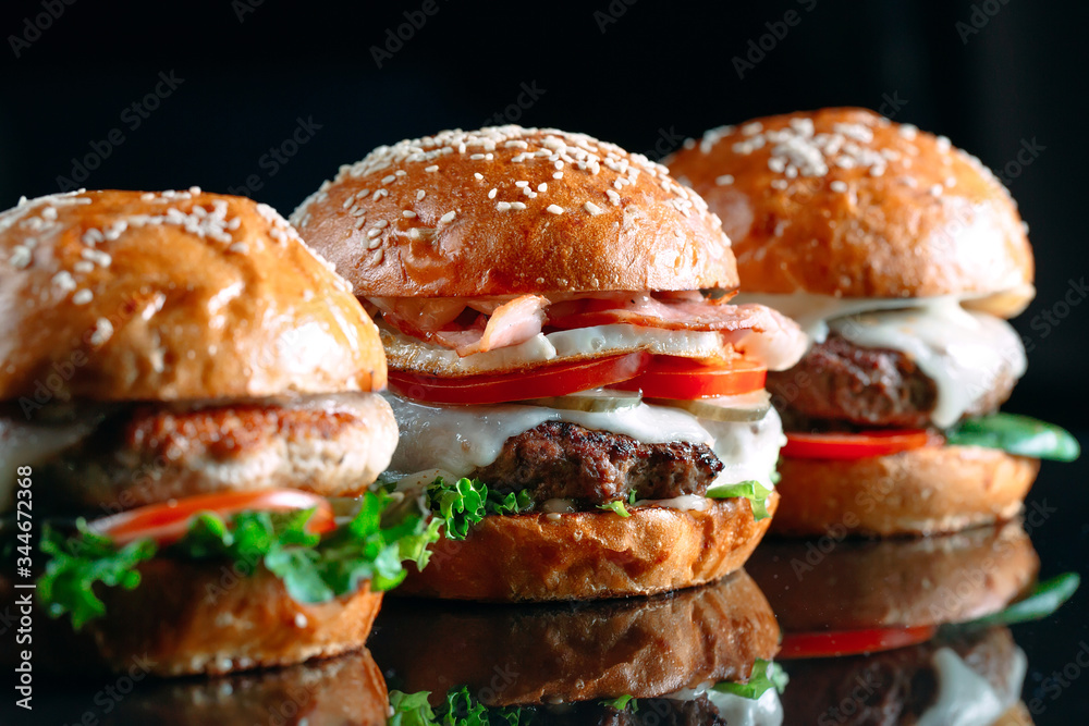 Juicy beef Burgers on a black background. Juicy beef Burgers on a black background.