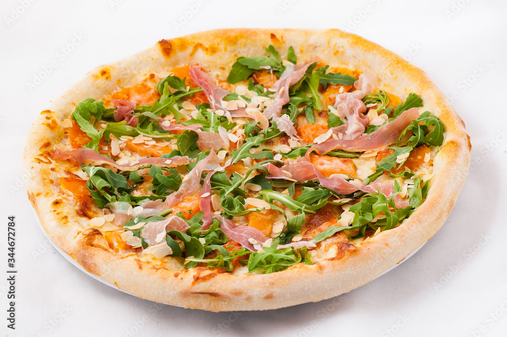 Pizza with arugula and jamon on a white background