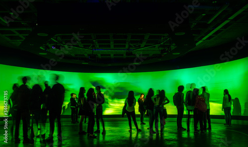 QUITO, ECUADOR, FEBRUARY 02, 2018: Indoor view of blurred people walking inside of a water exposition of marine life in Yuaku water museum located in the city of Quito, with green lights