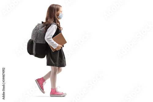 Schoolgirl with a backpack wearing a protective face mask and walking © Ljupco Smokovski