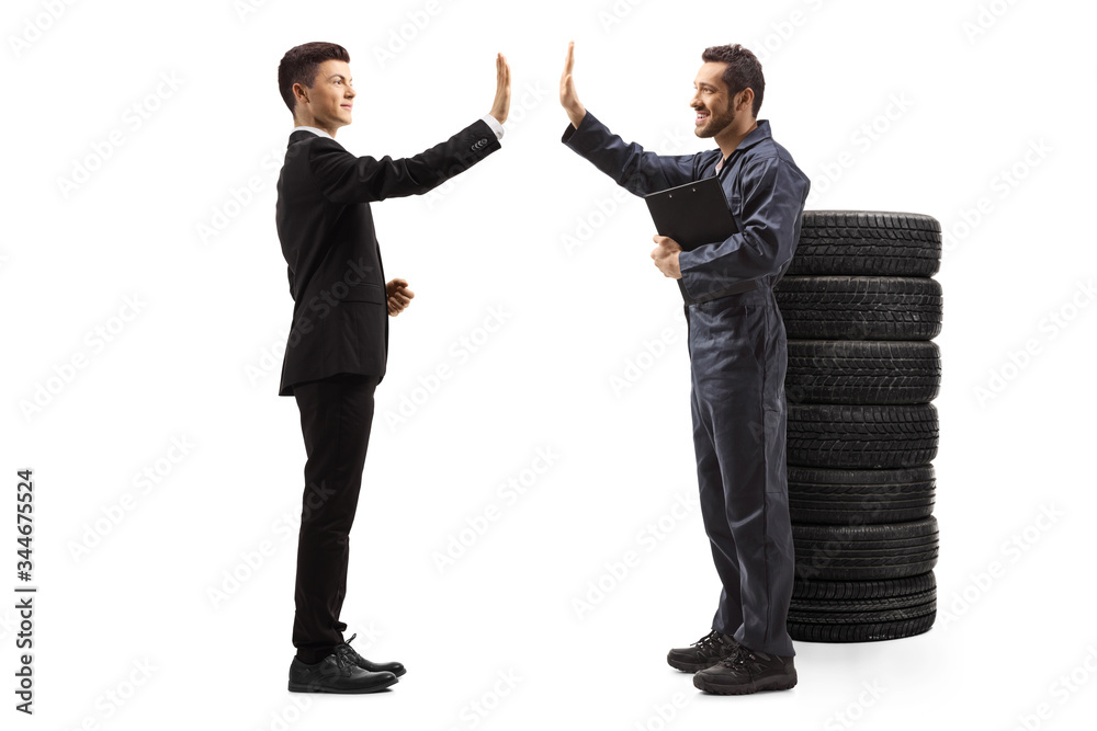 Young man in a suit gesturing high-five with an auto mechanic worker Young man in a suit gesturing high-five with an auto mechanic worker