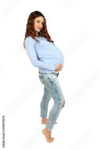 Adorable barefoot pregnant woman isolated on white