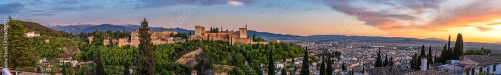 The palace of Charles V in Granada from the viewpoint of San Nicolas. Panoramic view of the Alhambra with Sierra Nevada and Granada in the background, incredible sunset.