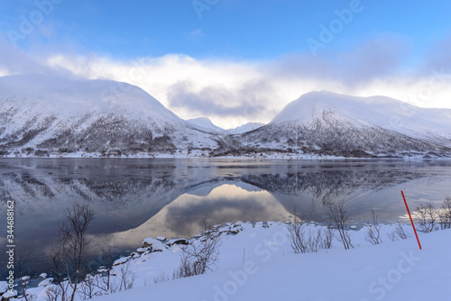 Simetria : Paisaje de fiordos noruegos en invierno en la provincia de Tromso, Nordland, Noruega 