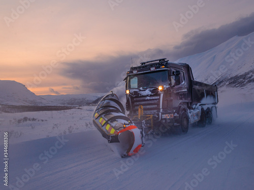 Maquina quitanieves trabajando al atardecer en las montañas del norte de Noruega