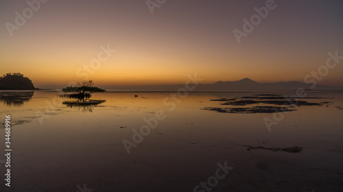 Magical vibrant gradual sunset scene with volcano or sunrise water like a glass in Sumbawa island, Indonesia
