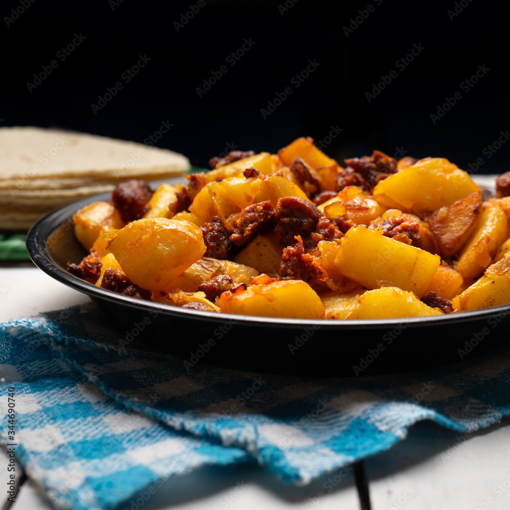 Mexican potatoes with chorizo on white background Mexican potatoes with chorizo on white background