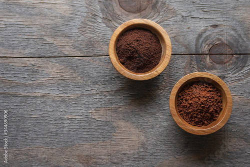 Instant and grounded coffee in bowls on a wooden background, top view with copy space