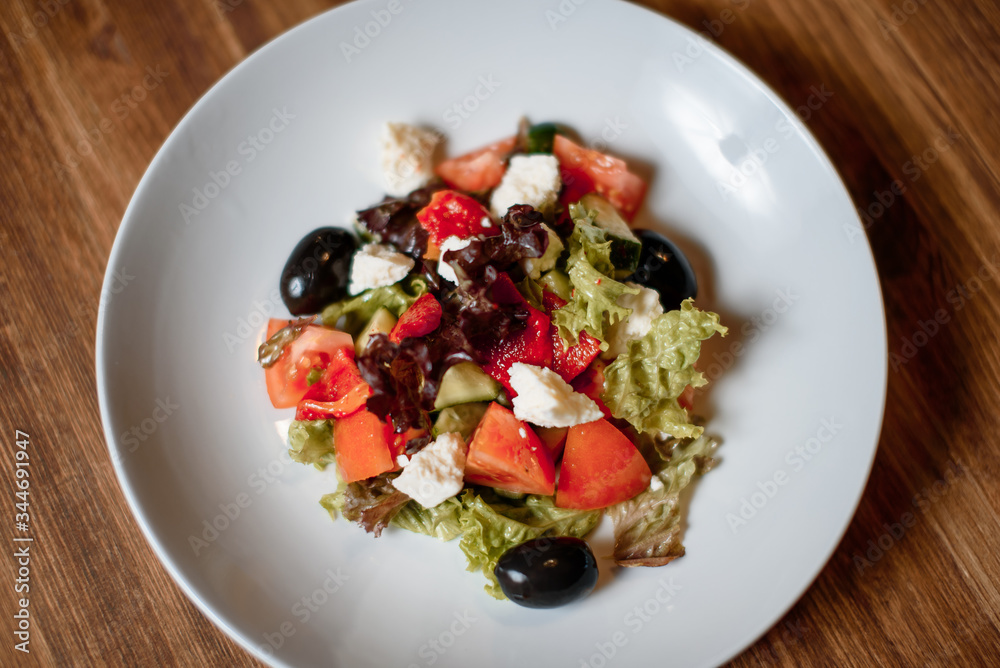 sresh organic salad and toasted bread in blue plate on wooden table. traditional dish menu served in a restaurant sresh organic salad and toasted bread in blue plate on wooden table. traditional dish menu served in a restaurant