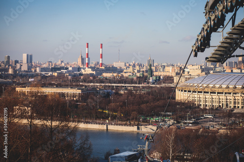 Sunny super-wide angle view from Sparrow Hills (Vorobyovy Gory), Moscow, Russia, with Luzhniki Stadium, Moscow cable car ropeway gondola, and scenery panorama beyond the city