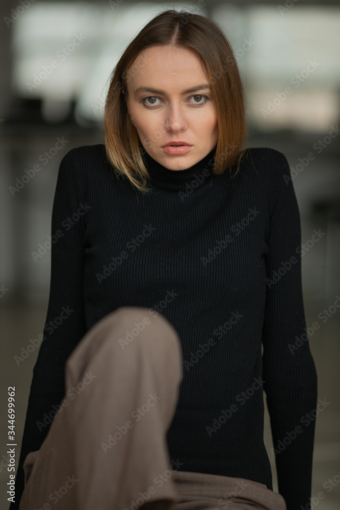close up portrait of stylish looking girl in black turtleneck with blue eyes, model posing in interior, studio background close up portrait of stylish looking girl in black turtleneck with blue eyes, model posing in interior, studio background