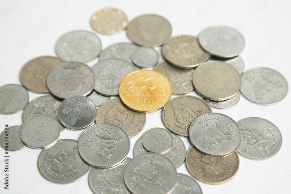 Pile of gray coins with a golden coin in the center - coins on white background - currency of Guatemala Pile of gray coins with a golden coin in the center - coins on white background - currency of Guatemala