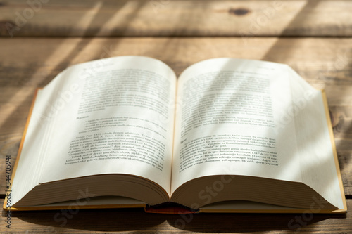 A thick book with open hardcover on a wooden floor