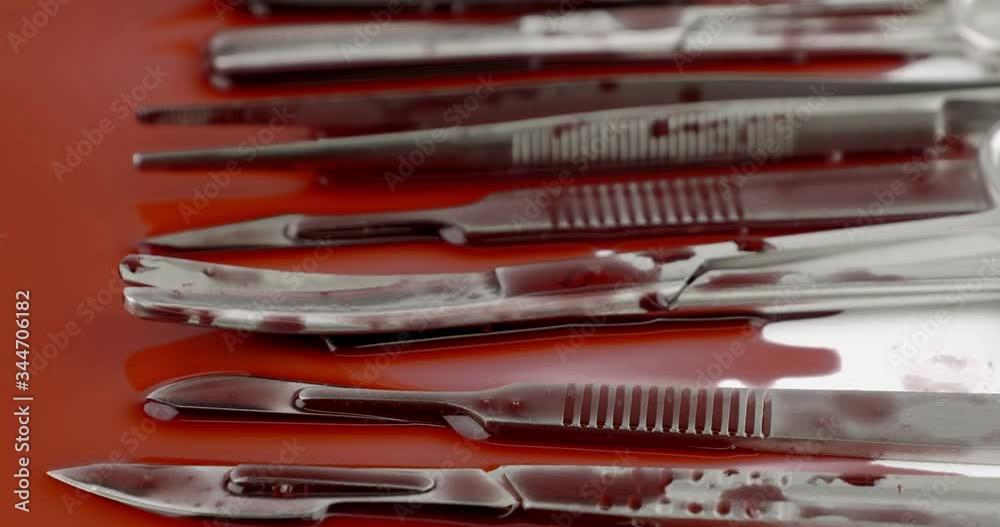 Truck shot close up of surgical instrument tools with blood, scalpel forceps tweezers, scissors for surgeon in surgery