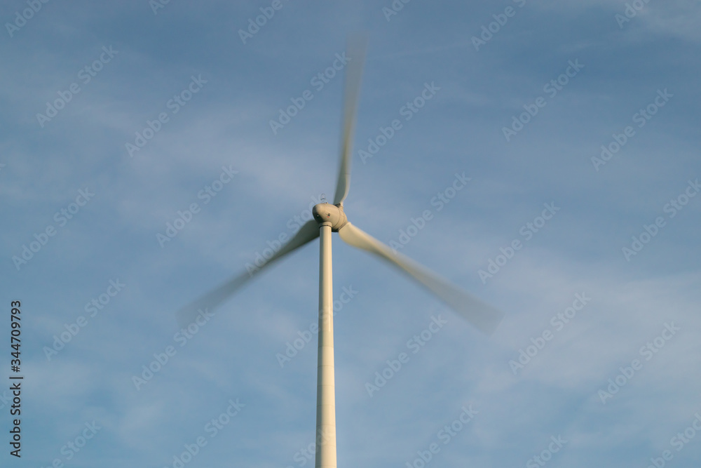 Wind turbine with fast moving propellers (long exposure photo) Wind turbine with fast moving propellers (long exposure photo)