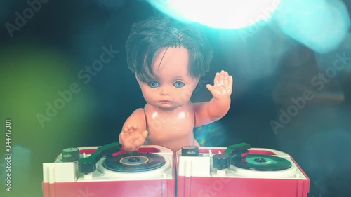 Plastic doll djing on toy record player.