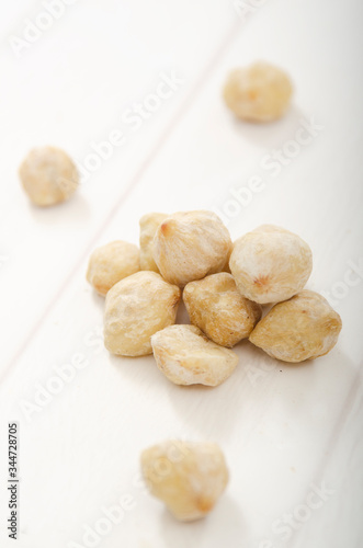 Candlenut on a wooden background (Aleurites moluccanus)