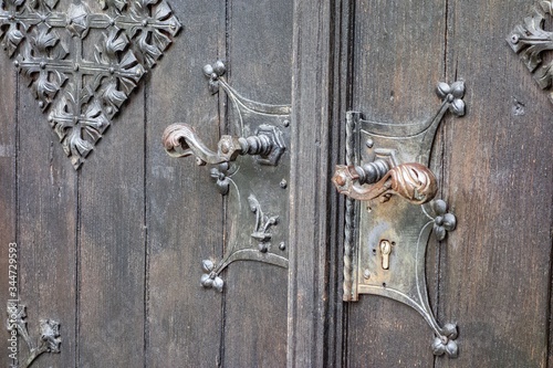 Closeup shot of the beautiful and vintage doorknobs on an old wooden door