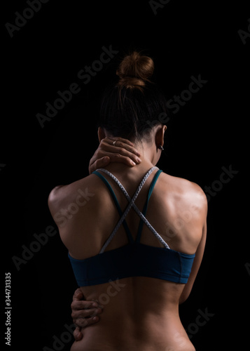 Neck pain during training. Athlete running asian woman runner with sport injury in sports bra rubbing and touching upper back muscles 