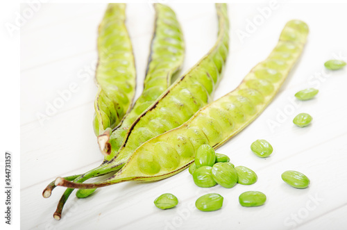 Petai, pete or stinky bean, is asian vegetable. take photo in white background. 
Good news is that petai has significant health benefits and has been used in folk medicine to treat diabetes, hyperte photo