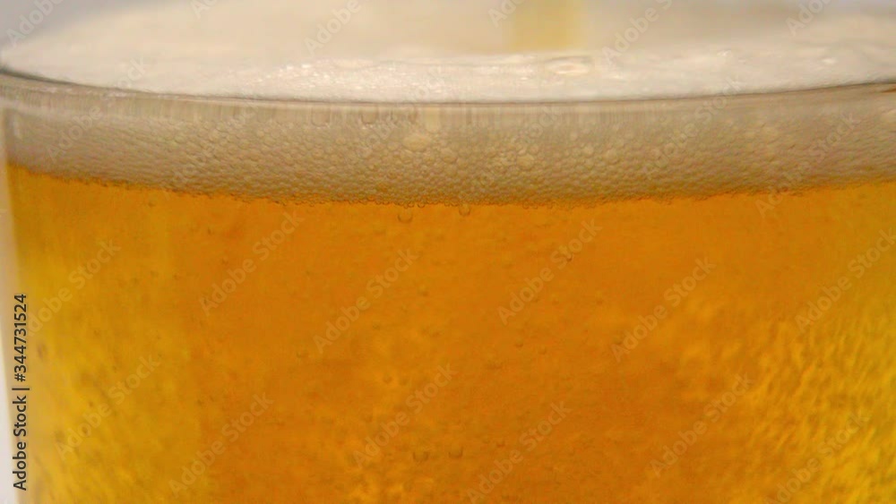 Overflowing glass of fresh beer in slow motion - pure refreshment Overflowing glass of fresh beer in slow motion - pure refreshment