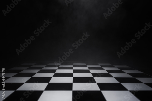 Murais de parede empty chess board with smoke float up on dark background