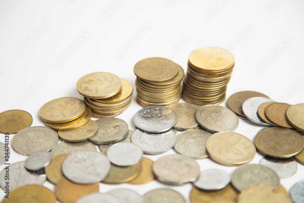 Coins stacked in small towers - Coins isolated from white background - Pile of queztales currency of Guatemala Coins stacked in small towers - Coins isolated from white background - Pile of queztales currency of Guatemala