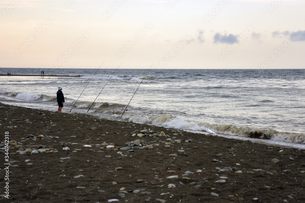 рыбак рыбачит на морском пляже 