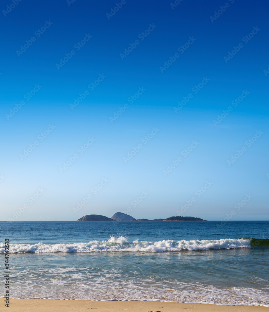 Ipanema Beach. Rio de Janeiro, Brazil. Beautiful view of the beach, the sea and islands in front of the coast of Rio. For design, space in the sky for place text. Copy space.
