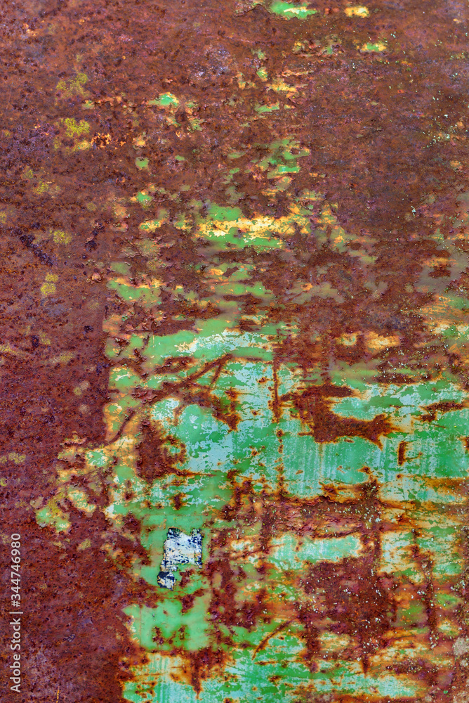 Multicolored background: rusty metal surface with flaking and cracking texture.