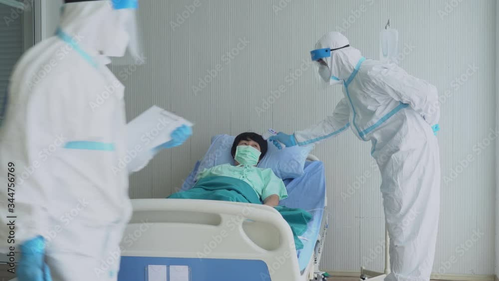 doctor and nurse in personal protective equipment or ppe treating the patient who had pneumonia from covid-19 or coronavirus infection in isolation room in hospital. medical concept doctor and nurse in personal protective equipment or ppe treating the patient who had pneumonia from covid-19 or coronavirus infection in isolation room in hospital. medical concept