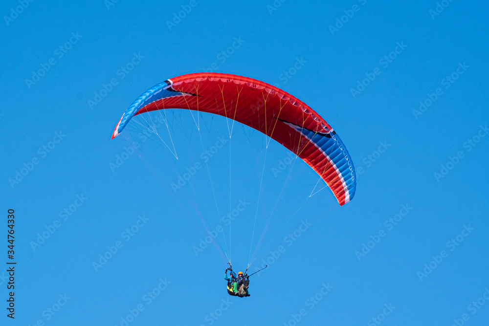 Paraglider in the sky. Parachute. Pilot. Free fall. Blue sky Paraglider in the sky. Parachute. Pilot. Free fall. Blue sky