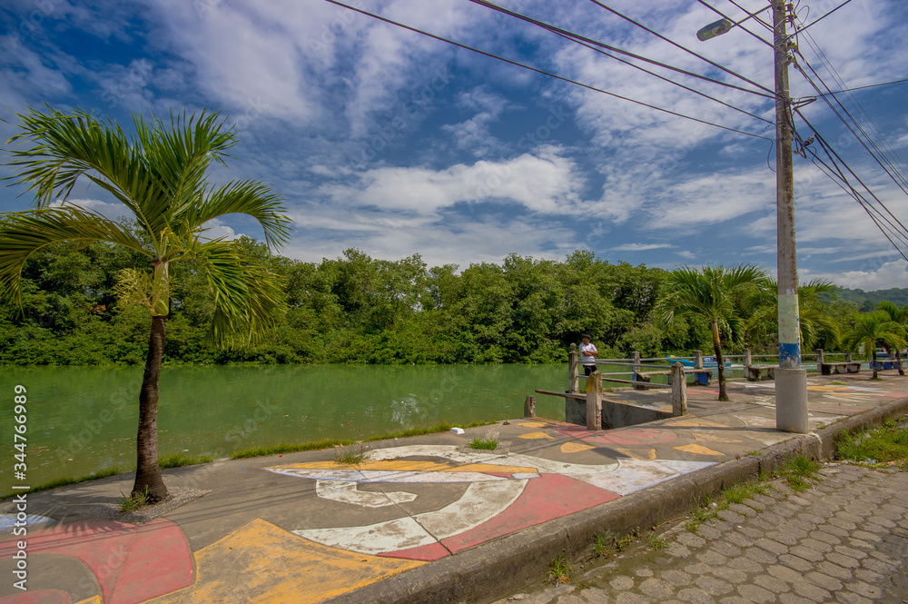 Fototapeta premium ATACAMES, ECUADOR - March 16, 2016: Unidentified man enjoying the view near of a river in Atacames, Ecuador