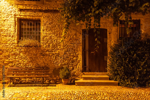 Borgo medievale di Strassoldo. Fotografia notturna, finestre sbarrate, porta e banchina di antico edificio. photo