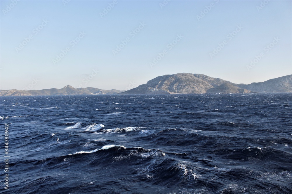 An island in the middle of the sea is deserted, its hills and peaks are visible from afar.