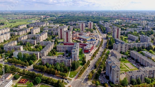 Aerial panoramic view of the southern part of Siauliai city in Lithuania.Old soviet union buildings with green naturearound and yards full of cars in a sunny day. © Evaldas