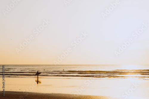 Ocean sunset  surfer backlit silhouette  warm orange colour