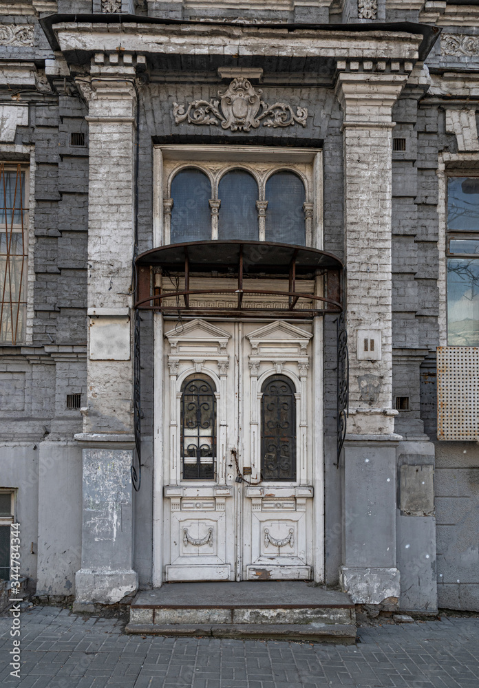 entrance to the old building. Arch of house facade. Architectural details of abandoned retro building.