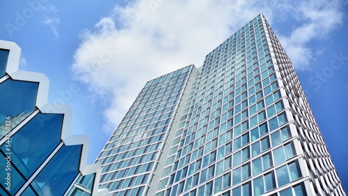 Structural glass wall reflecting blue sky. Abstract modern architecture fragment. View of a modern glass skyscraper, modern office building. Modern office facade fragment with blue glass.