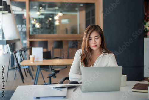 Portrait of beautiful asian woman working financial report with laptop computer at office.
