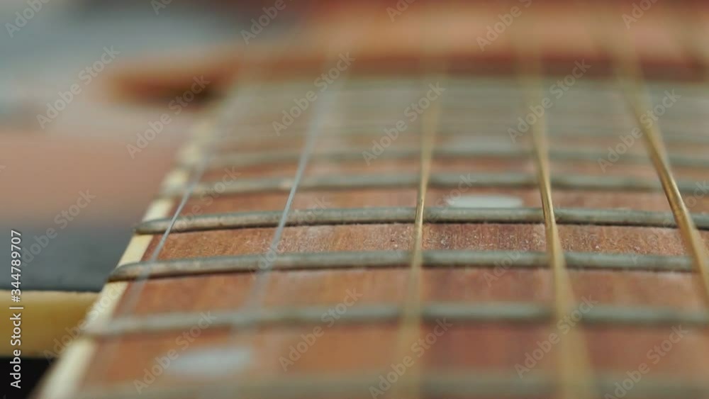 Closeup detail of guitar strings and frets for making music. Selective focus Closeup detail of guitar strings and frets for making music. Selective focus