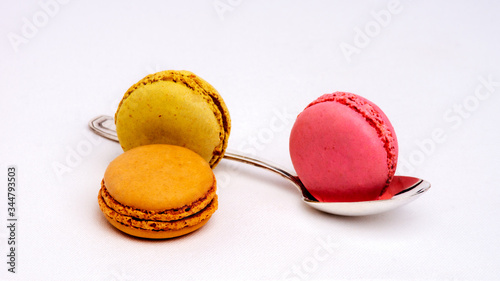 Macarons de couleurs avec petite cuillère sur fond blance photo