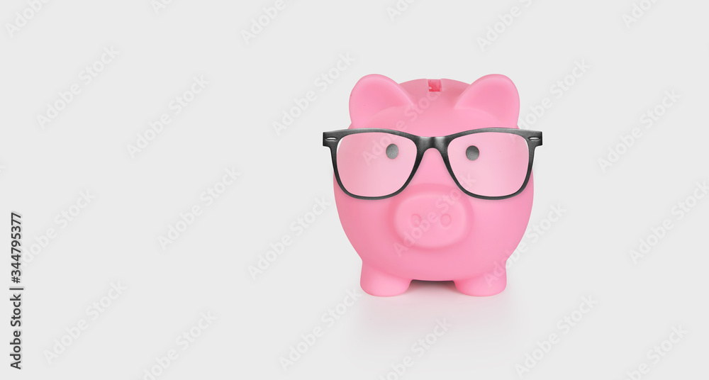 Pink piggy bank with glasses isolated on a white