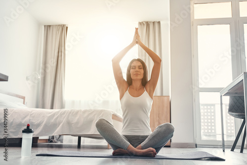 Relaxed young woman sitting in yoga pose