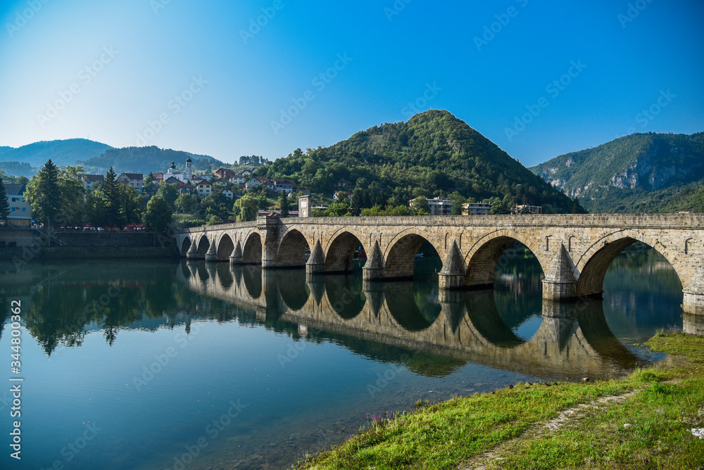 The Ottoman Mehmed Pasa Sokolovic Bridge in Visegrad, Bosnian mountains, with fantastic sky scape and river reflection. Bosnia and Herzegovina..