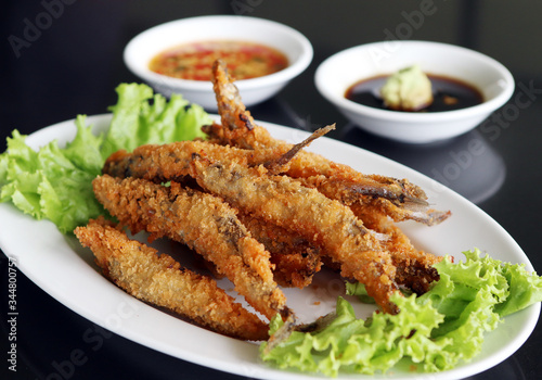 Capelin fish fried style japan serve with spicy sauce and white sauce.