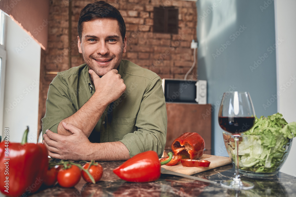 Dark-haired Caucasian male leaning on the countertop Dark-haired Caucasian male leaning on the countertop