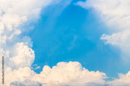 Blue hole in sky with bright light in clouds